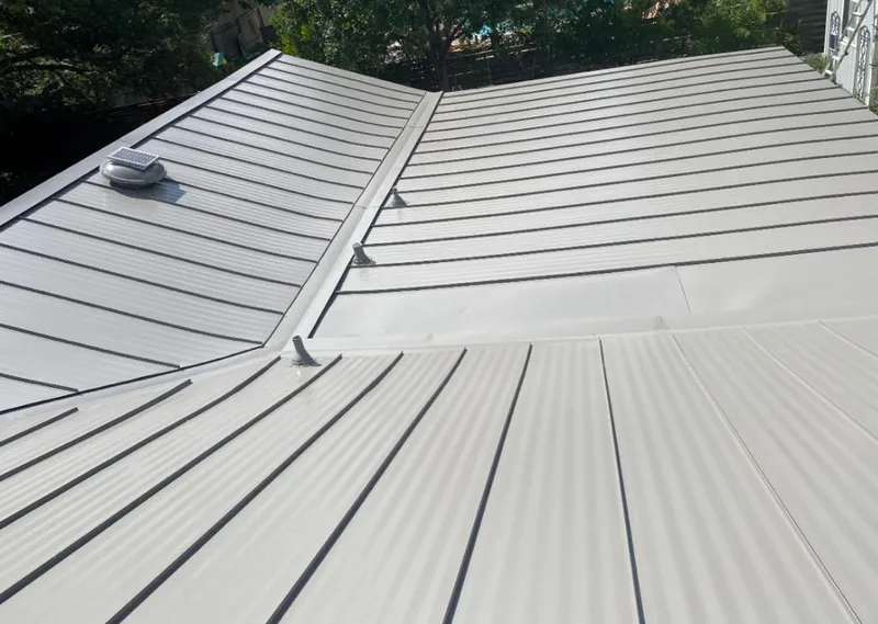 Solar attic fan installed on a metal roof for Roof Ventilation in Kingsford